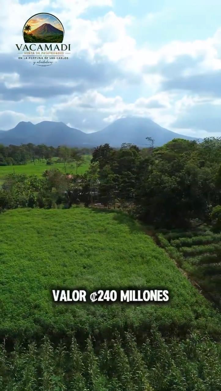Vacamadi property listing showing green farmland valley with volcanic mountains in background, priced at 240 million