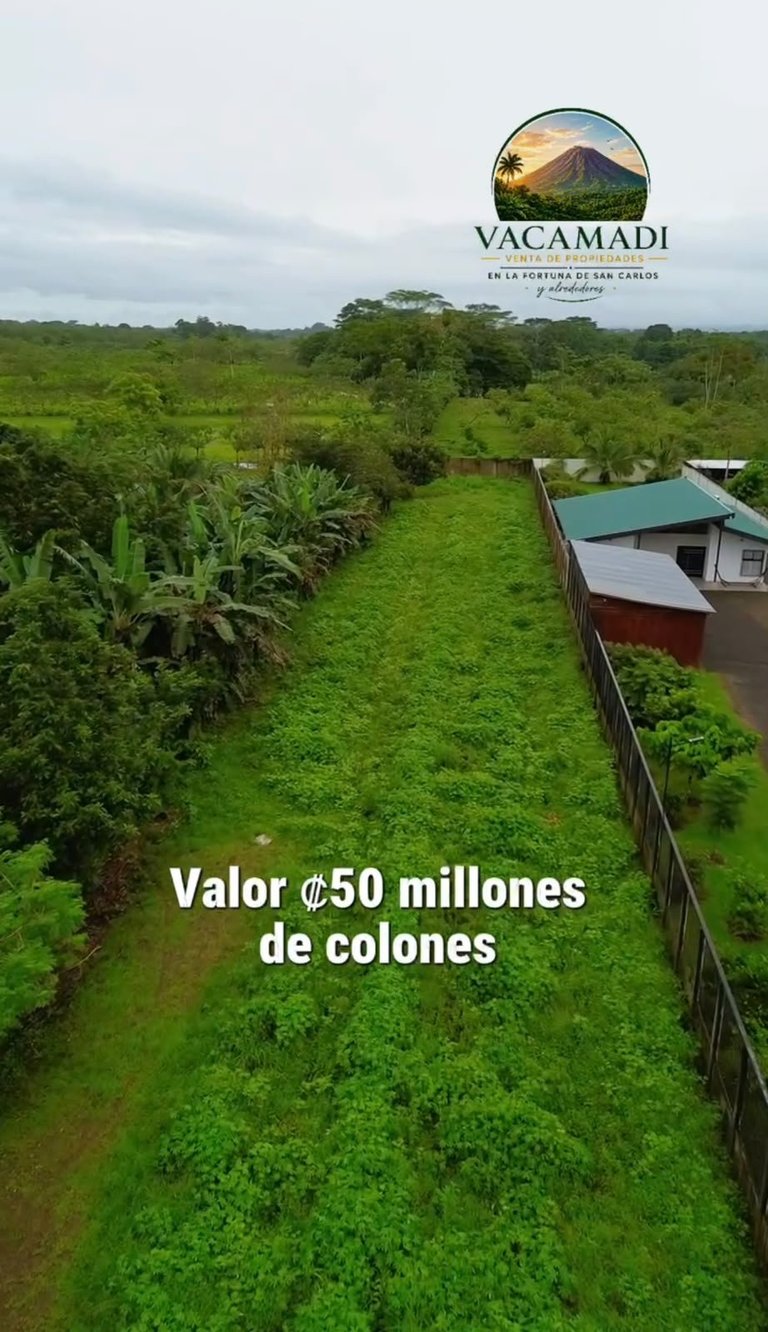 Vista aérea de terreno verde en San Isidro de La Fortuna de San Carlos, Costa Rica, valorado en 50 millones de colones, con el logo Vacamadi